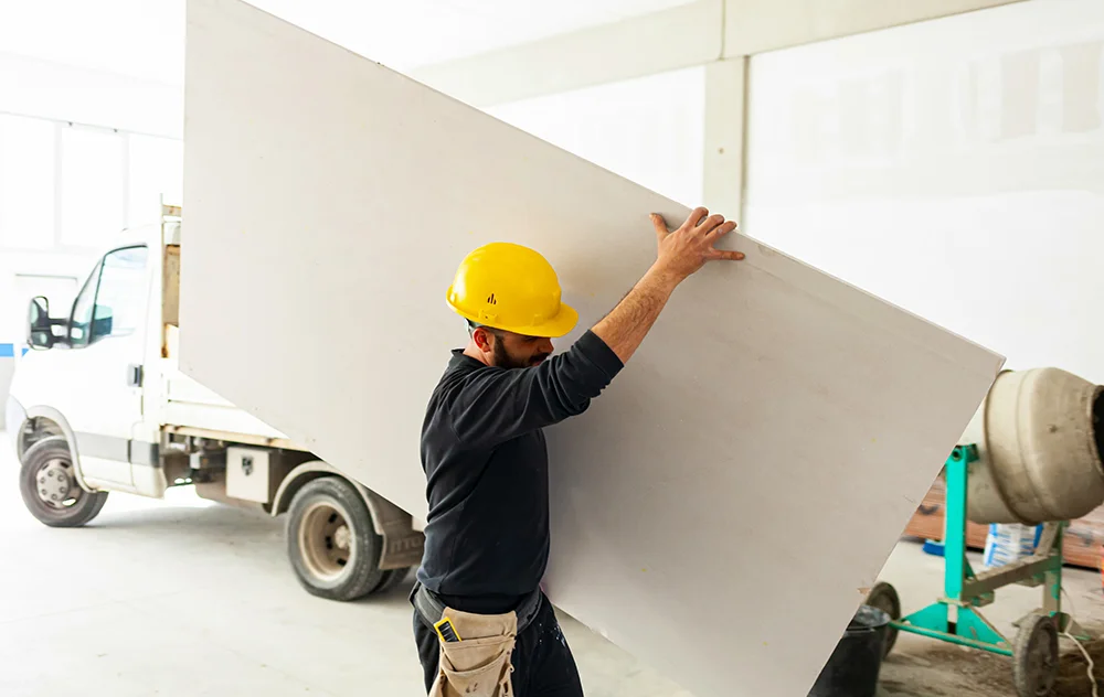 man carrying drywall