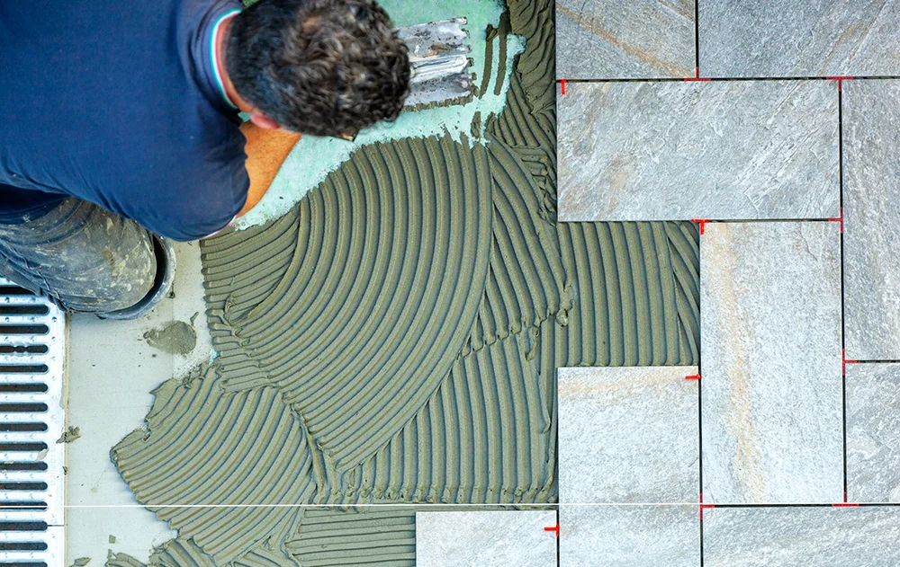 man tiling a bathroom